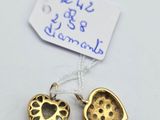 a close up of two gold heart shaped charms on a white surface