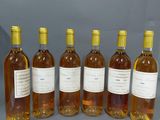 six bouteilles de vin sont alignées sur une table