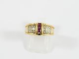 une bague en or jaune sertie de trois diamants et d'un rubis