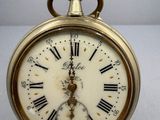 une horloge en or avec des chiffres romains sur le cadran