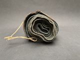 a rolled up roll of blue jeans on a gray surface
