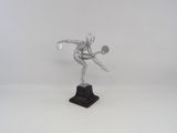 silver statue of a tennis player holding a racket on a white surface