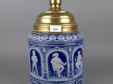 a blue and white vase with a gold lid and a gold top