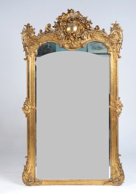 un miroir au cadre doré richement décoré, dont le bord est orné d'un motif élaboré