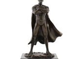 the bronze statue of a man in a cape stands on a marble base