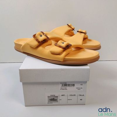 yellow leather sandals with buckles are on top of a white box