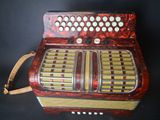 an old red accordion sitting on top of a black table
