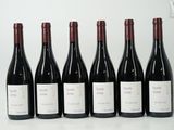 six bouteilles de vin sont alignées sur une table