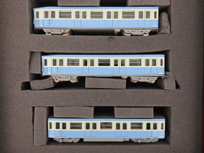 trois wagons bleus et blancs dans une boîte