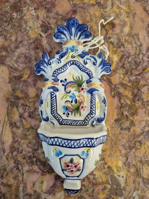 une photo d'un vase bleu et blanc accroché au mur