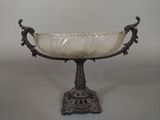 a glass bowl that is on a stand on a table