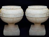 deux vases blancs posés l'un à côté de l'autre sur un fond noir