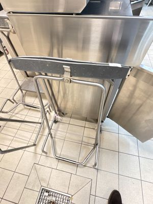a stainless steel table and chairs in a kitchen