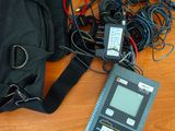 un sac noir posé sur une table, à côté d'un ordinateur portable et d'autres appareils électroniques