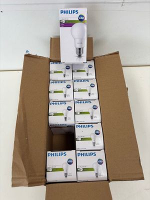 Des boîtes d'ampoules Philips sont empilées sur un carton