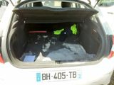 a white car with its trunk open and a pair of yellow vests in the back