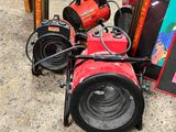 a red heater sitting on the ground next to a pile of other items