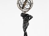 une statue en bronze représentant un homme tenant un globe terrestre sur la tête