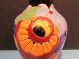a vase with a flower painted on it sitting on a table