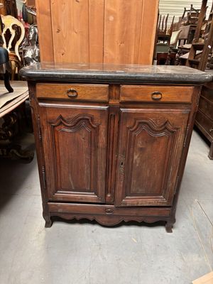 une armoire en bois surmontée d'un plateau en marbre