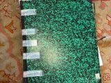 a book with a green cover sitting on a rug