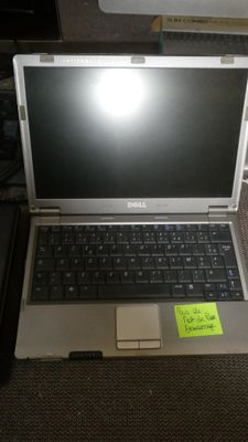 a laptop computer sitting on a desk with a sticky note attached to it