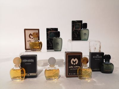 plusieurs flacons de parfum posés sur une surface blanche