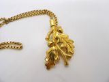 gros plan d'un collier en or sur une surface blanche
