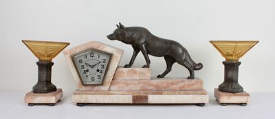 a statue of a dog and a clock on a table