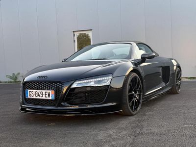 the audi sports car is parked in front of a building