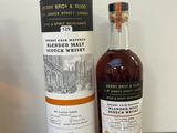 deux bouteilles de whisky posées sur un plan de travail, à côté d'une bouteille de liqueur