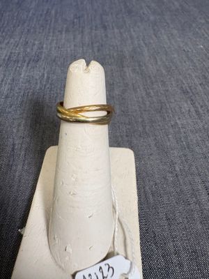 une bague posée sur un porte-bague muni d'une étiquette portant un nom