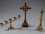 three candles and a cross on the table