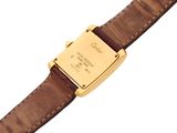 a close up of a watch on a brown strap on a white surface