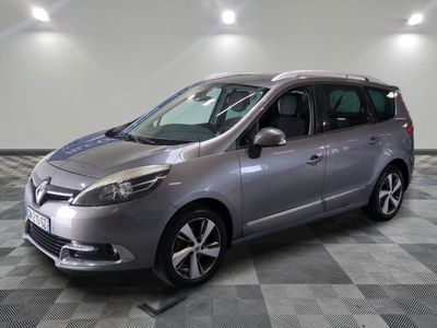 La camionnette argentée est garée sur un sol à damier dans un garage.