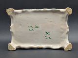 a small white plate with green writing on it
