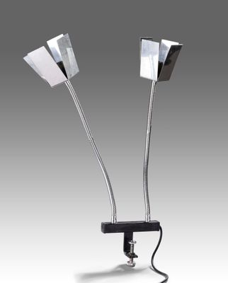 une paire de lampes chromées posées sur un pied noir, sur fond gris