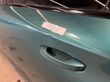 a blue car with a sticker on the door handle