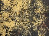 a black and yellow graffiti on a wall next to a fire hydrant