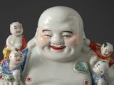 a statue of a laughing buddha with a group of small children