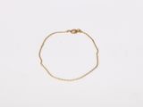 a gold chain bracelet with a tiny heart on it