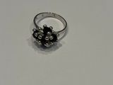 gros plan d'une bague en argent sur une surface blanche