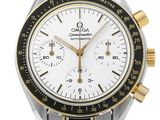 a close up of a silver and gold watch with a white face