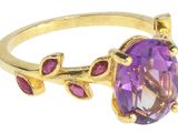 gros plan d'une bague en or avec une pierre violette