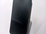 the back of a black cell phone sitting on top of a white table