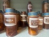 many jars of liquid sitting on a shelf in a room