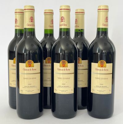 six bouteilles de vin sont alignées sur une surface blanche