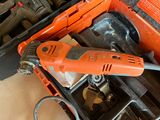 an orange corded drill in a tool box with other tools