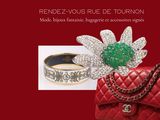 a red book with a red purse and a green flower on it