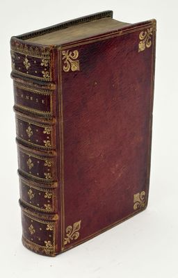 an old leather book with gold trimmings on a white surface